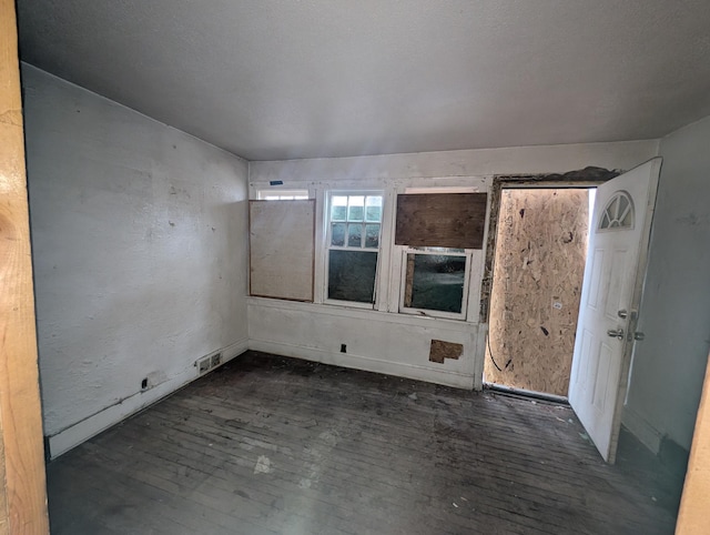 unfurnished room with dark wood-type flooring