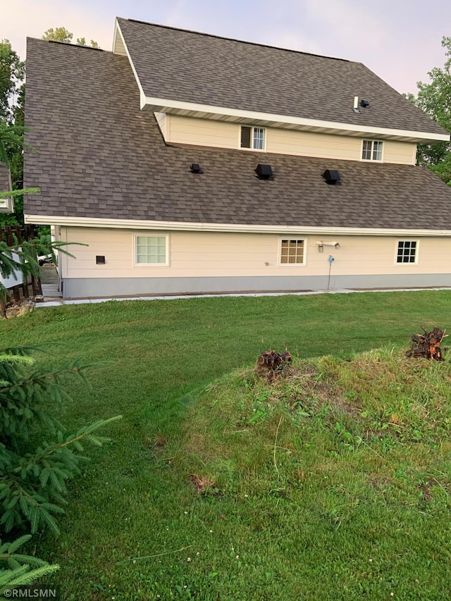 property exterior at dusk featuring a lawn