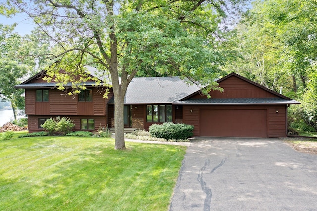 tri-level home featuring a garage and a front lawn