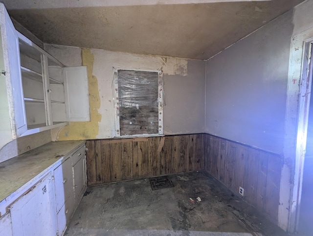 kitchen with white cabinets and wooden walls