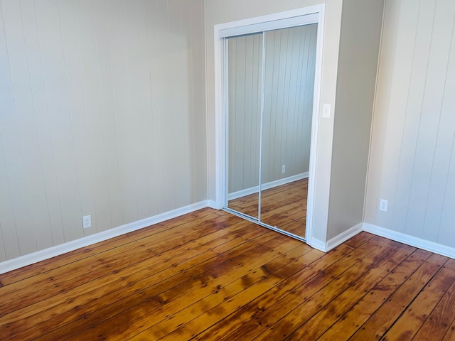 unfurnished bedroom with hardwood / wood-style flooring and a closet