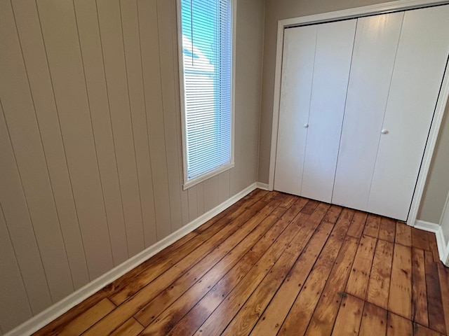 unfurnished bedroom featuring a closet and hardwood / wood-style floors