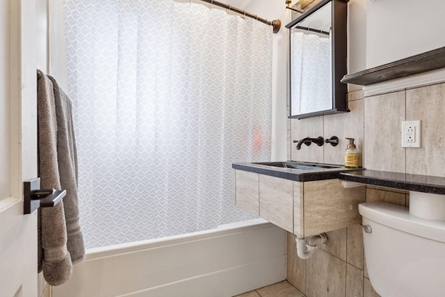 full bathroom featuring toilet, tile patterned floors, shower / tub combo with curtain, and sink