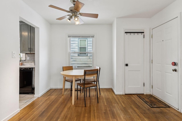 dining space with ceiling fan and light hardwood / wood-style flooring