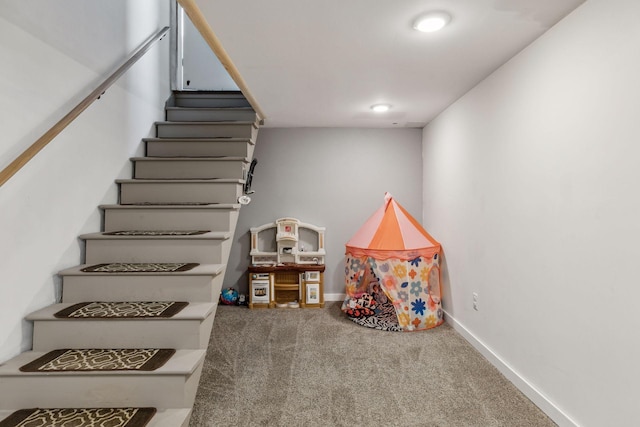 staircase featuring carpet