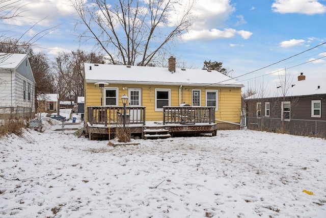 snow covered back of property featuring a wooden deck