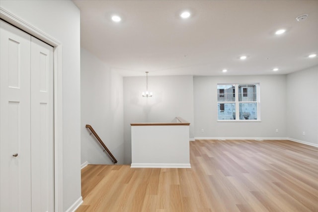 interior space featuring light wood-type flooring and an inviting chandelier