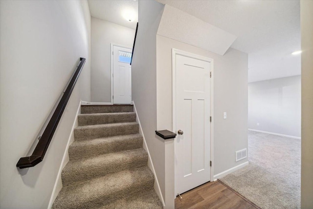 stairs featuring wood-type flooring