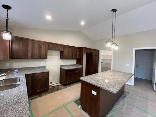 kitchen with lofted ceiling, a kitchen island, decorative light fixtures, and dark brown cabinetry