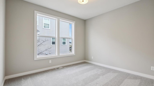 spare room featuring light carpet