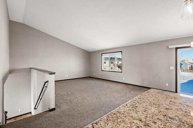 unfurnished living room featuring carpet floors and lofted ceiling