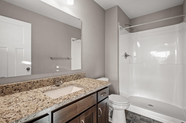 bathroom with toilet, walk in shower, and vanity