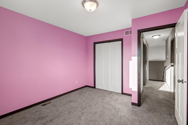 unfurnished bedroom featuring carpet flooring and a closet