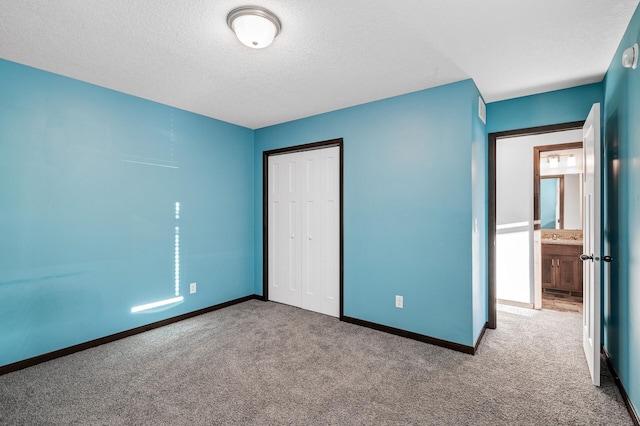 unfurnished bedroom with a textured ceiling, carpet floors, and a closet