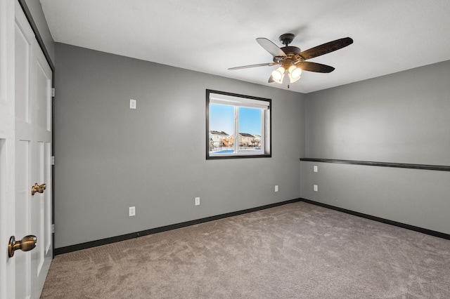 carpeted empty room featuring ceiling fan