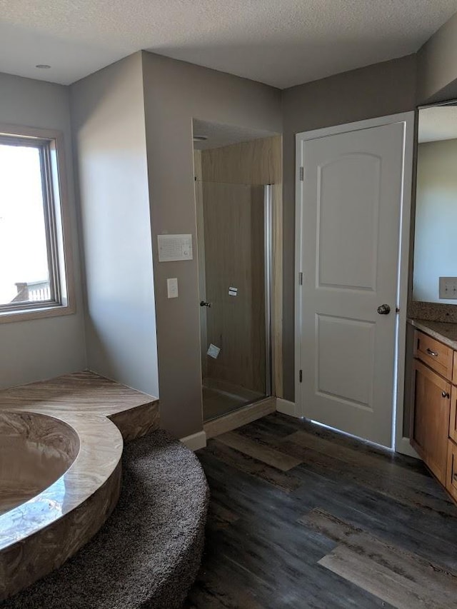 bathroom with hardwood / wood-style flooring, vanity, a textured ceiling, and a shower with shower door