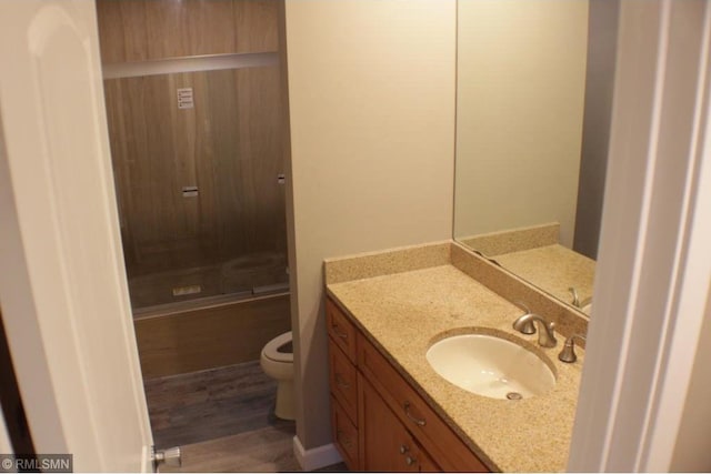 bathroom with vanity, wood-type flooring, and toilet