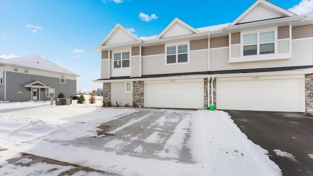 townhome / multi-family property featuring a garage and central air condition unit