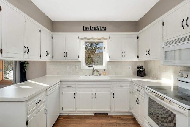 kitchen with sink, white appliances, white cabinets, and dark wood-type flooring