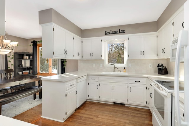 kitchen with sink, white cabinetry, white appliances, and decorative backsplash