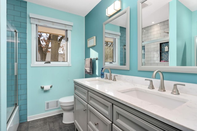 full bathroom featuring toilet, vanity, tile patterned flooring, and shower / bath combination with glass door