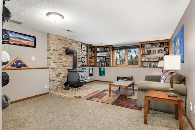 carpeted living room featuring a textured ceiling and a wood stove