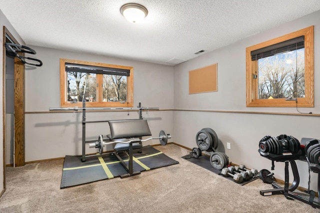 workout room with a textured ceiling and carpet flooring