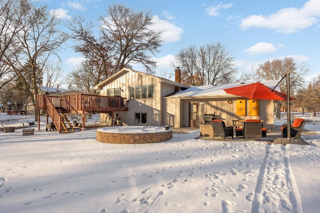 snow covered house with a wooden deck