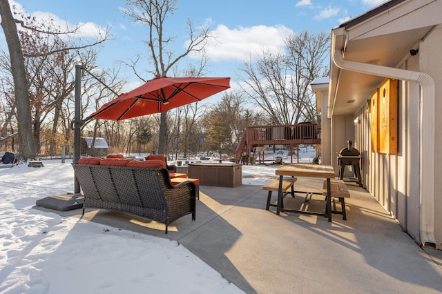 snow covered patio featuring outdoor lounge area and a wooden deck