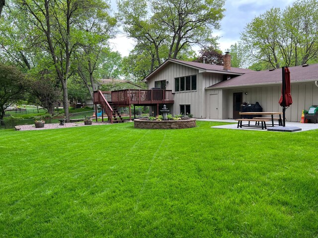 rear view of house featuring a deck, a yard, and a patio