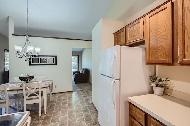 kitchen featuring crown molding, a chandelier, white fridge, and hanging light fixtures