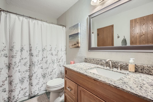 bathroom featuring a textured ceiling, vanity, and toilet