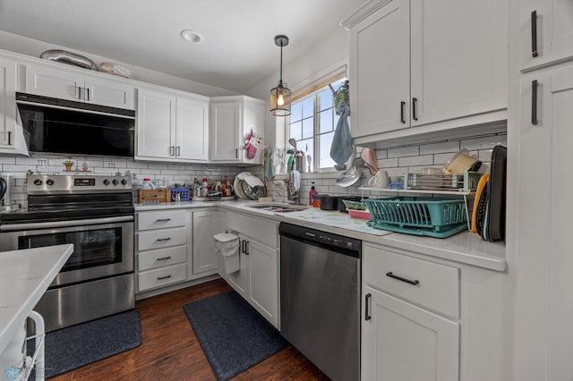 kitchen with white cabinets, stainless steel appliances, dark hardwood / wood-style flooring, and hanging light fixtures