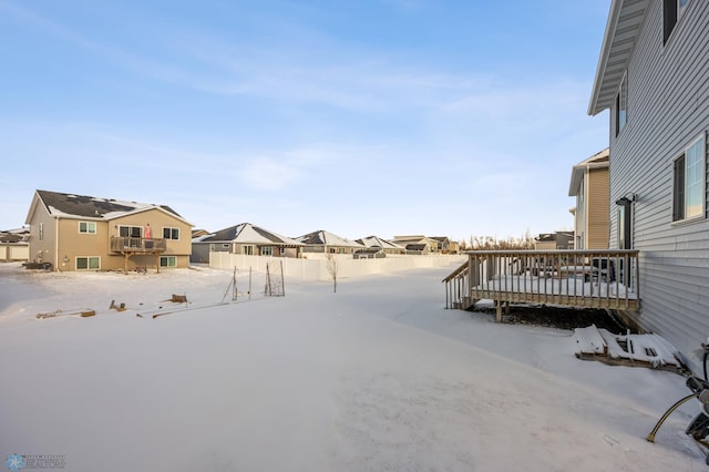 yard covered in snow with a wooden deck