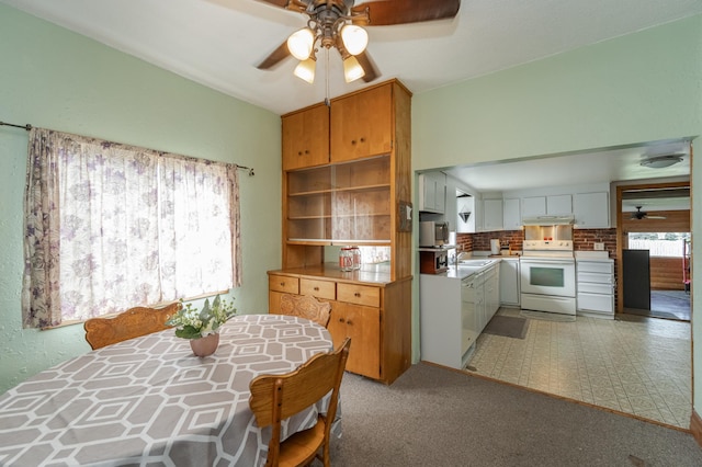 kitchen with ceiling fan, electric range, sink, and white cabinetry