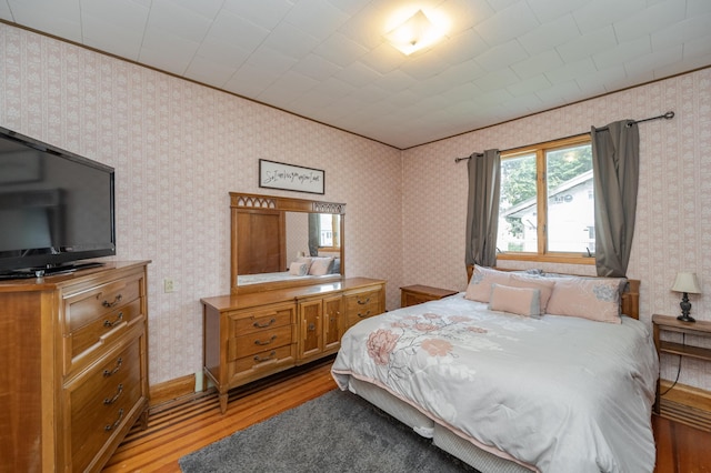 bedroom featuring ornamental molding and light hardwood / wood-style floors