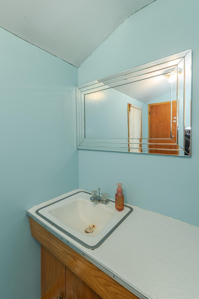 bathroom featuring lofted ceiling and vanity