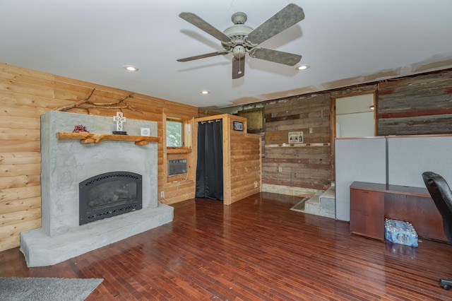 unfurnished living room featuring ceiling fan, dark wood-type flooring, wood walls, and log walls