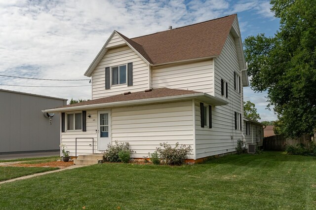 rear view of house with a lawn and central air condition unit