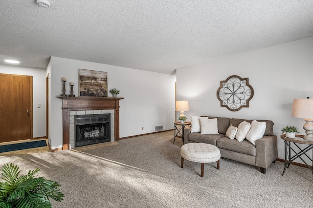 carpeted living room with a textured ceiling and a tiled fireplace