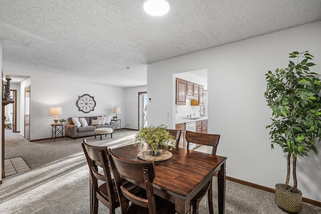 carpeted dining area featuring a textured ceiling and sink