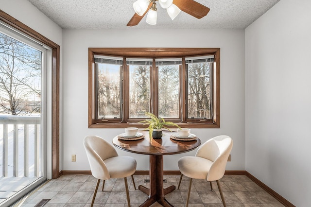 dining space featuring ceiling fan and a textured ceiling