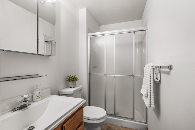 bathroom featuring toilet, tile patterned flooring, walk in shower, and vanity