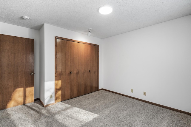 unfurnished bedroom featuring a closet, a textured ceiling, and carpet flooring