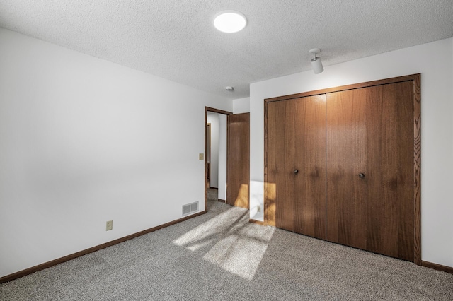 unfurnished bedroom with a closet, a textured ceiling, and carpet flooring