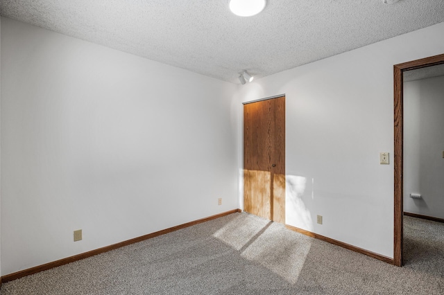 empty room with a textured ceiling and carpet flooring