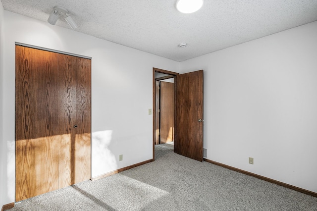 unfurnished bedroom with carpet, a closet, and a textured ceiling