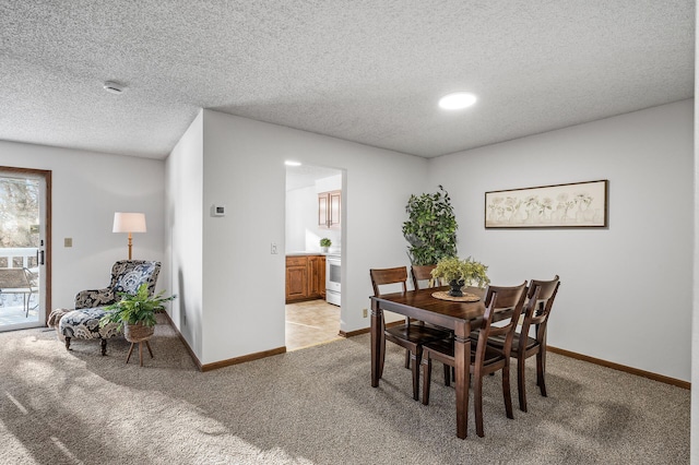 carpeted dining room with a textured ceiling