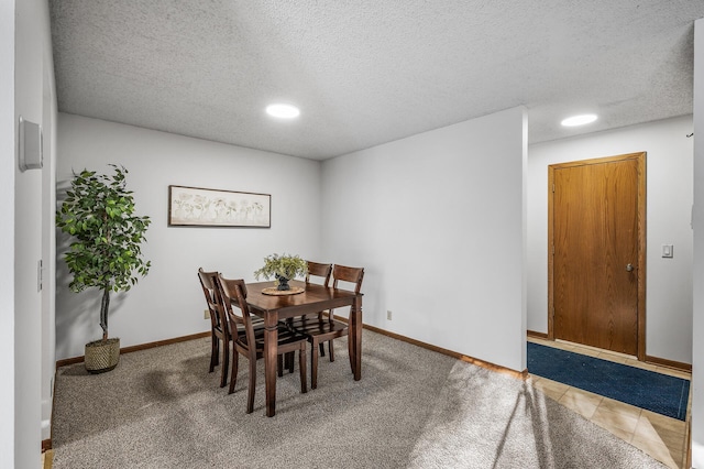 dining room featuring a textured ceiling and carpet