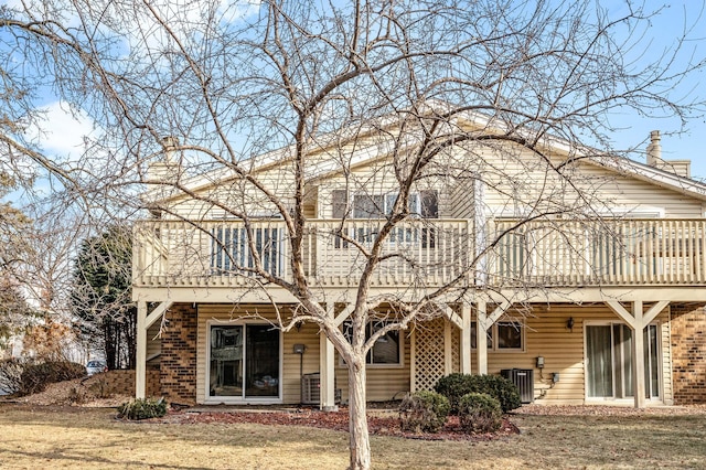 back of house with central AC unit and a lawn